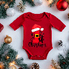 Red baby onesie with Christmas design on a bed of pine needles and ornaments.