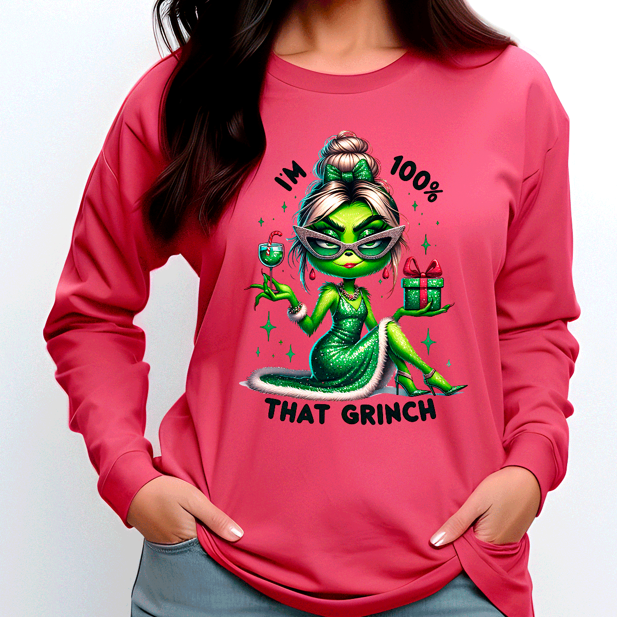 Person wearing a pink sweatshirt with a green character and text design.