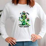 White long-sleeve shirt with a graphic design of a green character holding a gift and text 'IM 100% THAT GRINCH' worn by a person.