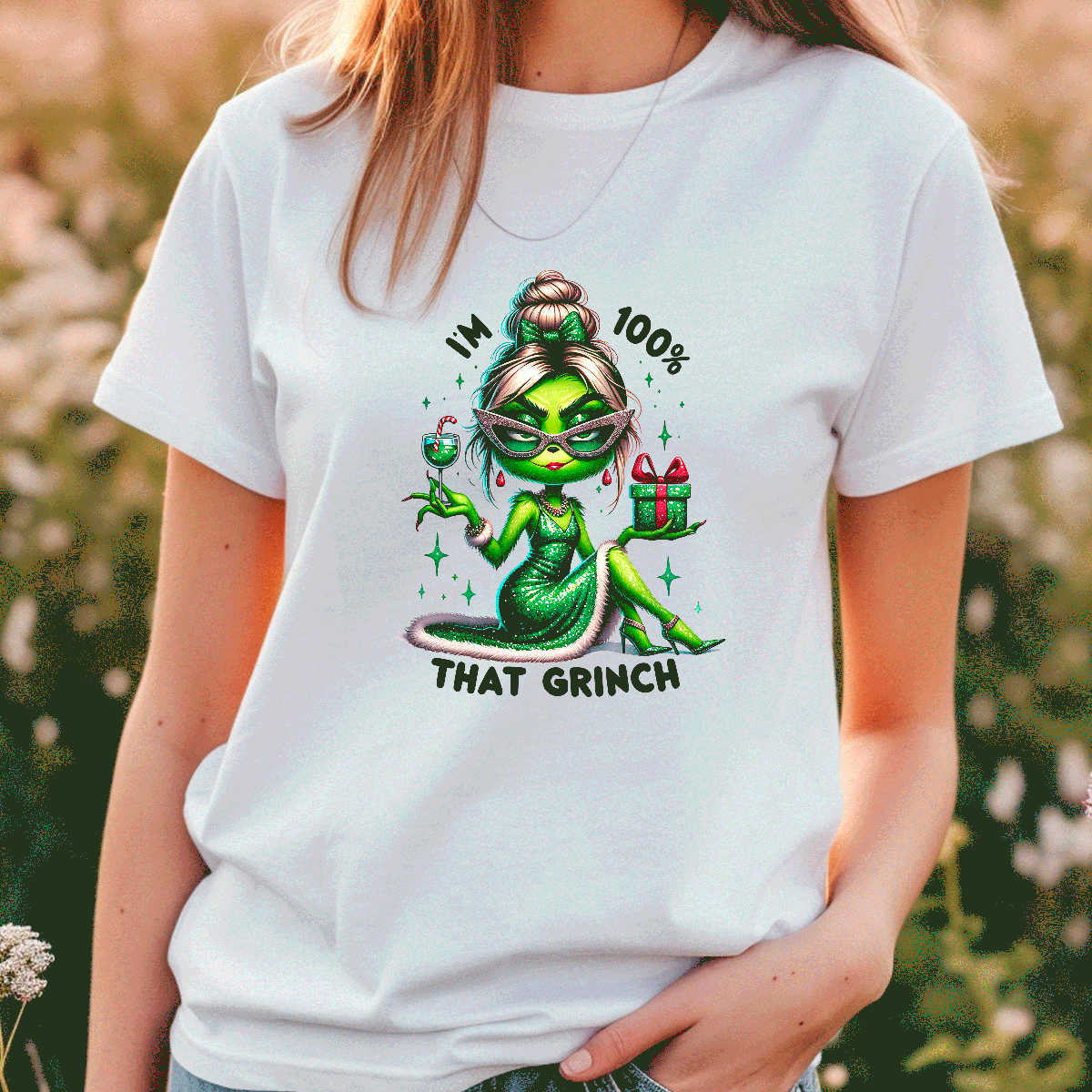 Person wearing a white t-shirt with a green character and text graphic, standing outdoors.