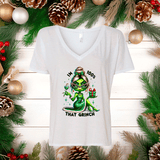 White V-neck t-shirt with a green alien design and text, surrounded by Christmas decorations.