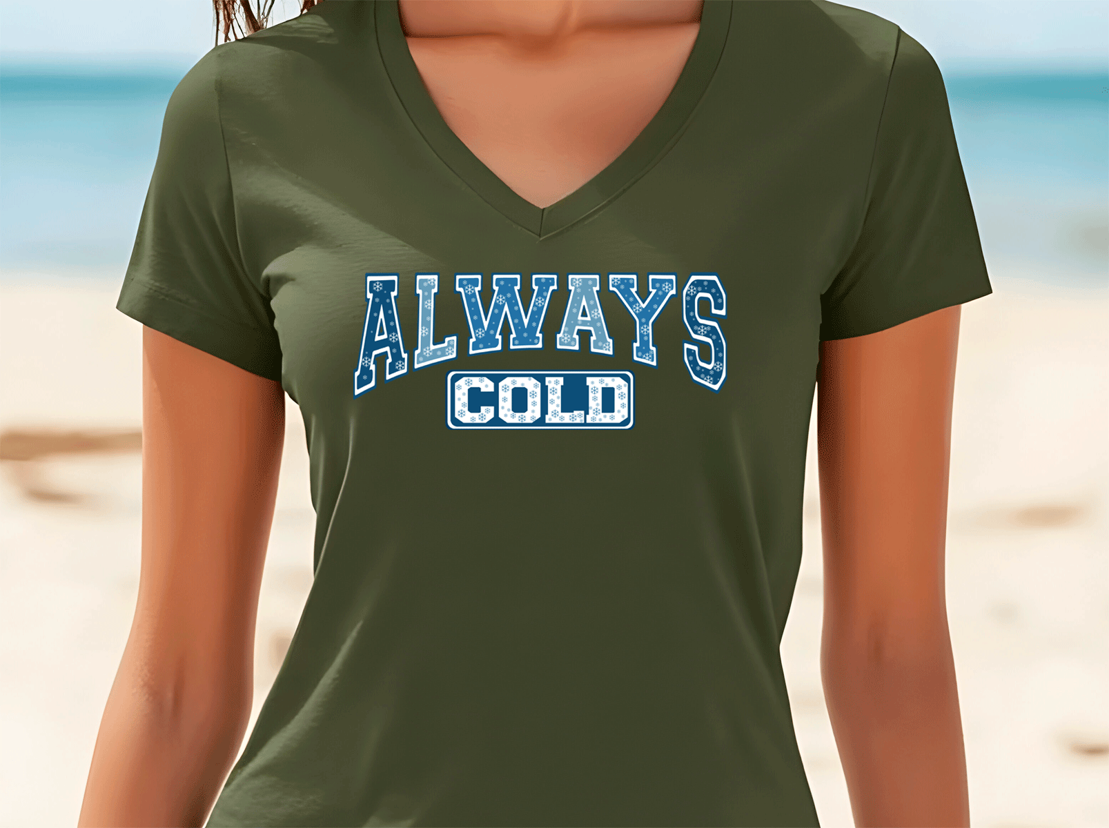 Person wearing a green t-shirt with 'ALWAYS COLD' text on a beach background