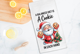 Kitchen towel with Santa Claus design and humorous text on a wooden cutting board with lemons.