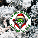Christmas ornament with a character in a Santa hat and text 'I've been watching. We need to talk' against a snowy tree background.
