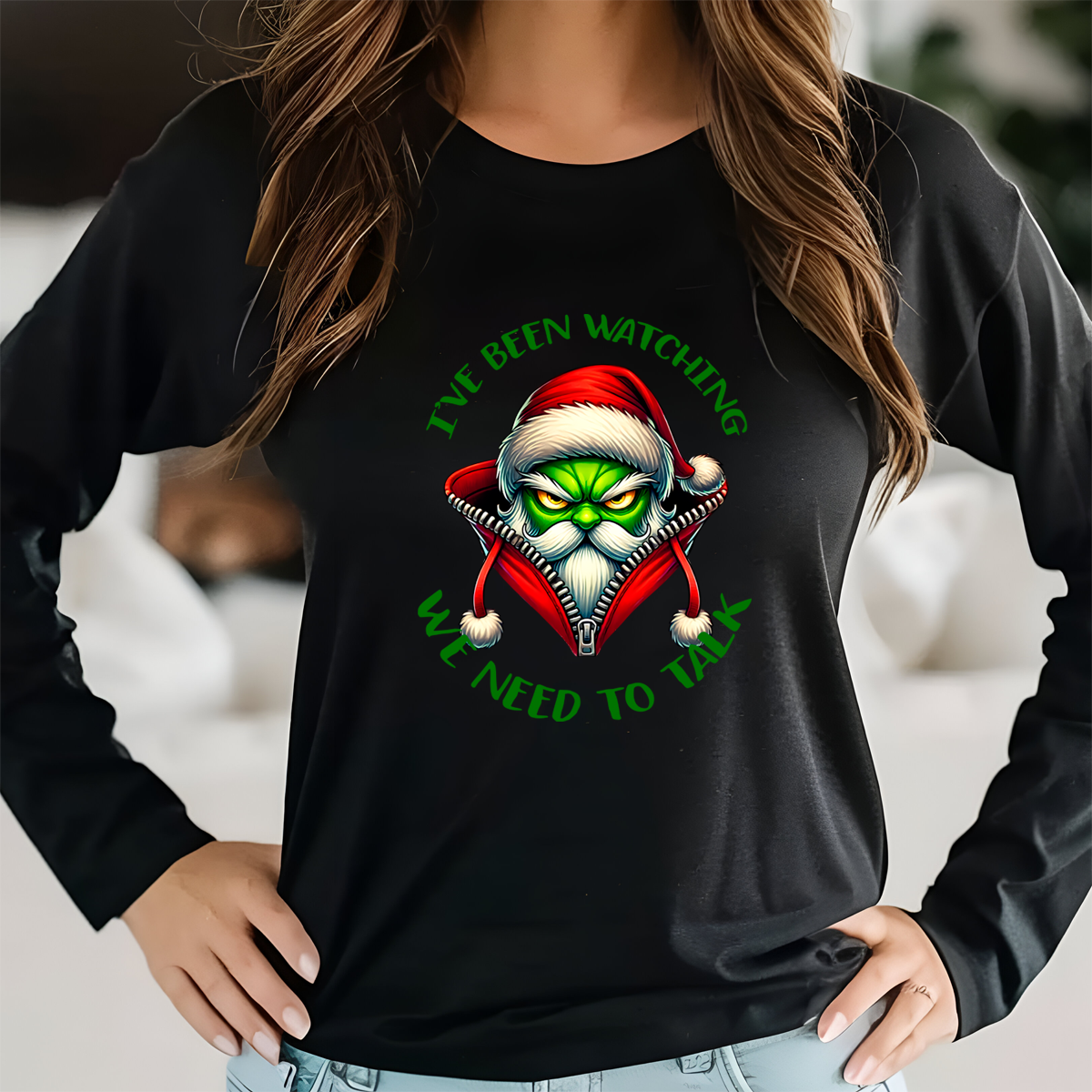 Black long-sleeve shirt with a graphic design of a character wearing a Santa hat and text, worn by a person.
