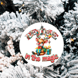 Christmas ornament with reindeer and text 'Believe in the magic' on a snowy tree background