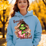 Person wearing a light blue hoodie with a graphic design and text, standing in an outdoor setting with trees.