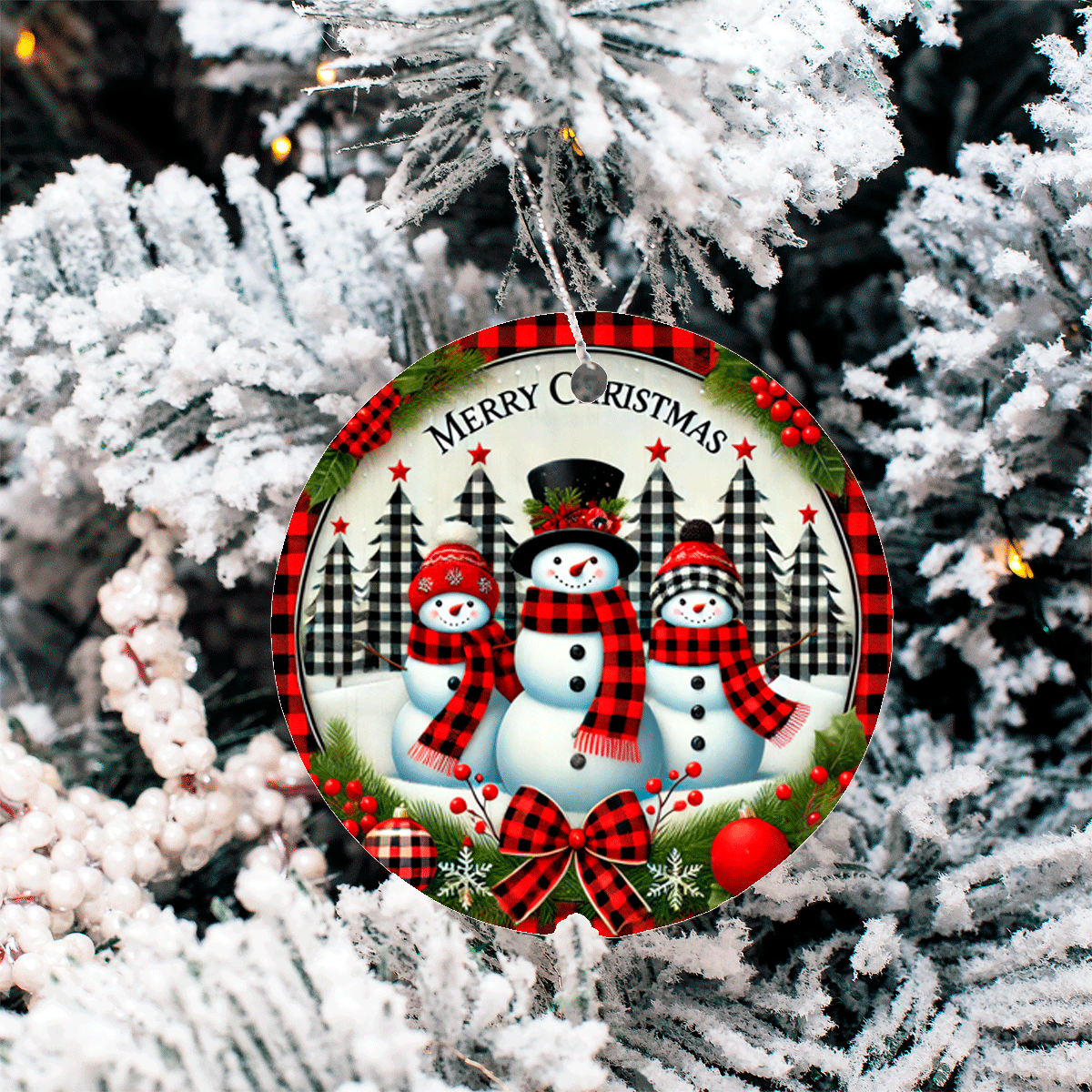 Christmas ornament with snowmen and plaid patterns hanging on a tree.