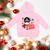 Pink hoodie with snowman design and 'Chill Bruh' text, surrounded by Christmas decorations on a white background.
