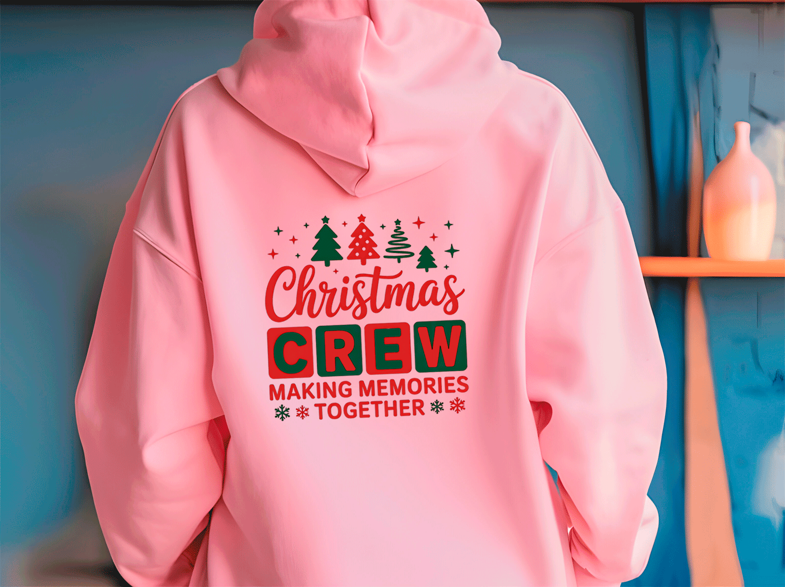 Pink hoodie with Christmas-themed text on a blue wall background