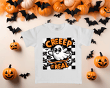White t-shirt with Halloween-themed design featuring a ghost and text, surrounded by pumpkins and bats on a beige background.