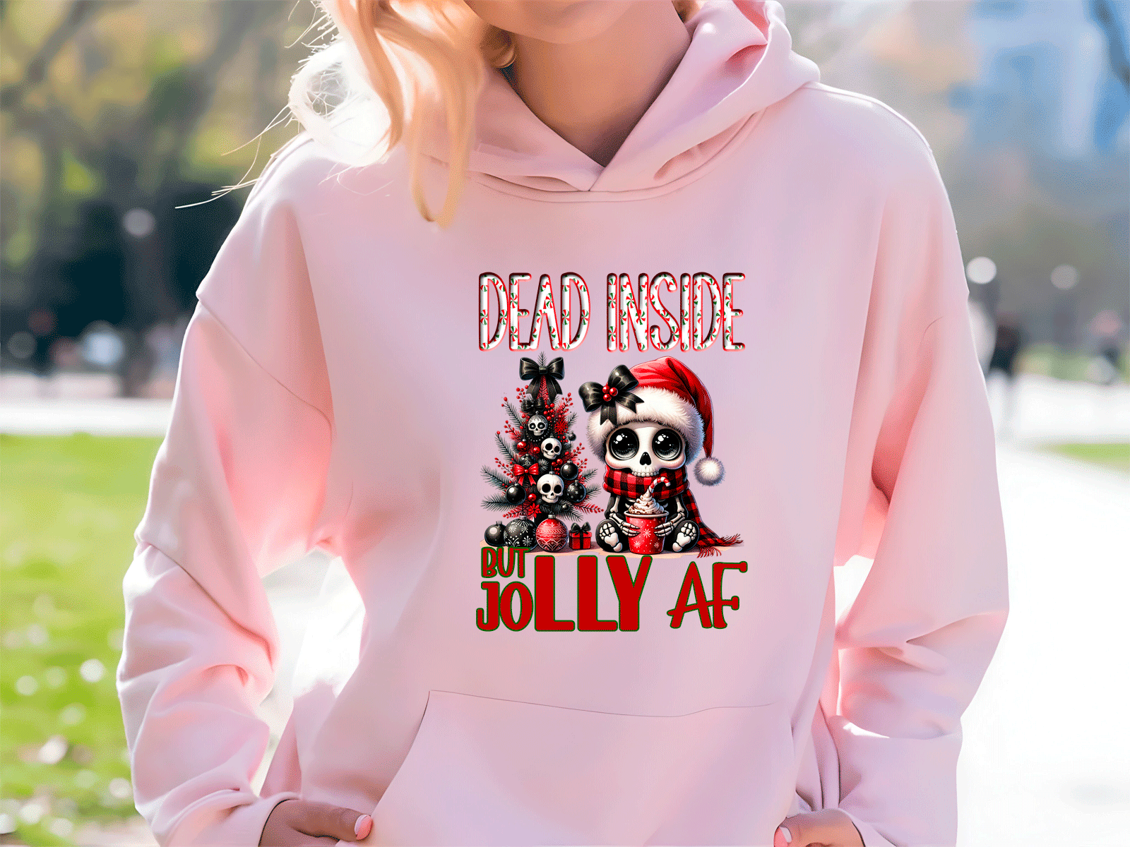 Person wearing a pink hoodie with a Christmas-themed design and text.