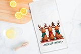 Tea towel with reindeer design and 'Deer-est Friends' text on a kitchen counter with lemons.