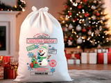 White Santa sack with festive design in front of a decorated Christmas tree and presents.