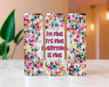 Three colorful tumblers with floral designs and text on a blurred indoor background