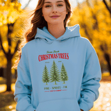 Person wearing a light blue hoodie with Christmas tree design in an outdoor setting