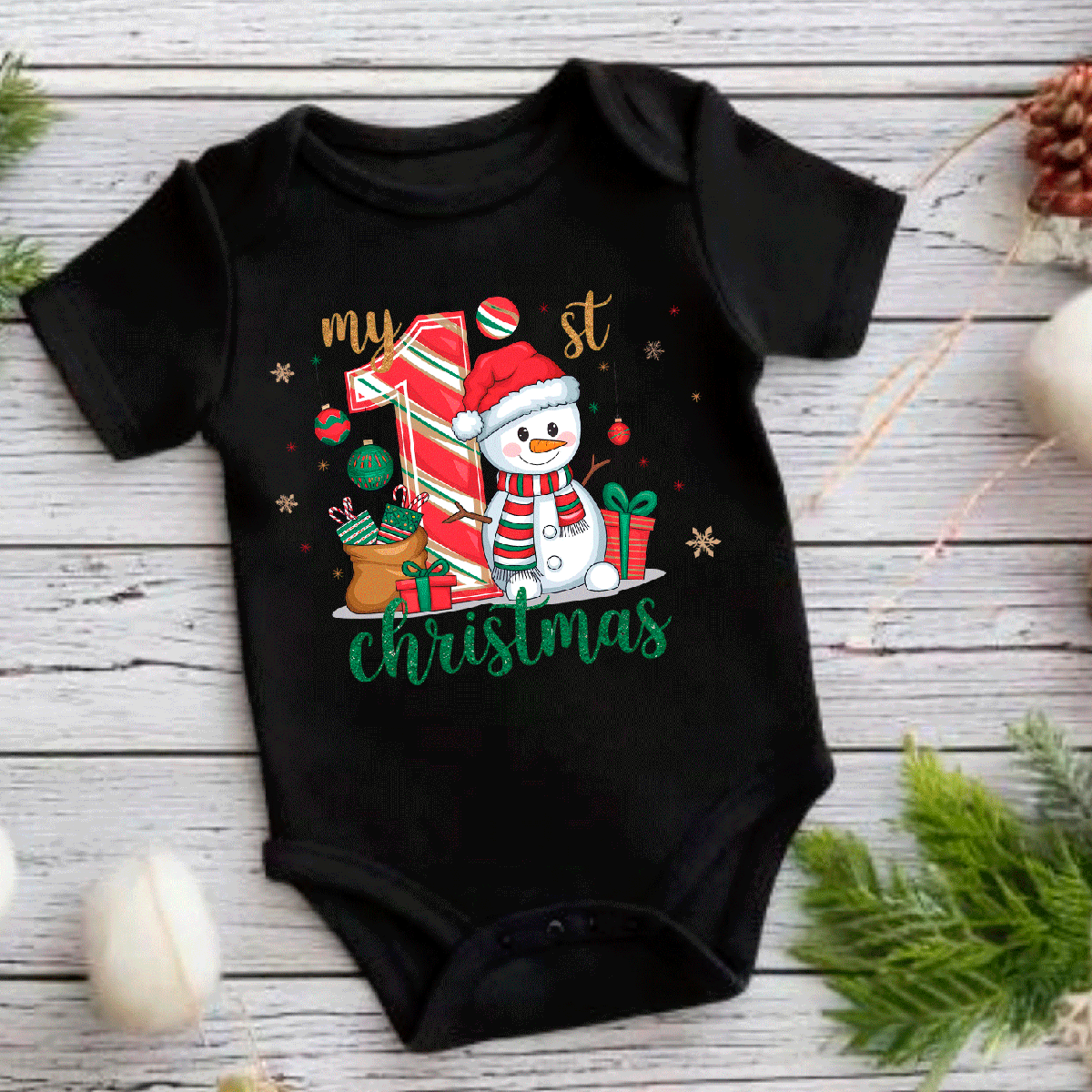 Black baby onesie with Christmas-themed design featuring a snowman and text on a wooden surface.
