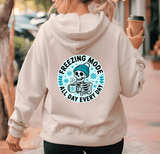 Person wearing a hoodie with a skeleton design and text 'Freezing Mode All Day Every Day' on the back.
