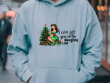 Light blue hoodie with Christmas-themed design and text on a blurred street background