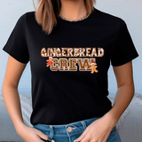 Person wearing a black t-shirt with 'GINGERBREAD CREW' text and gingerbread men graphics.