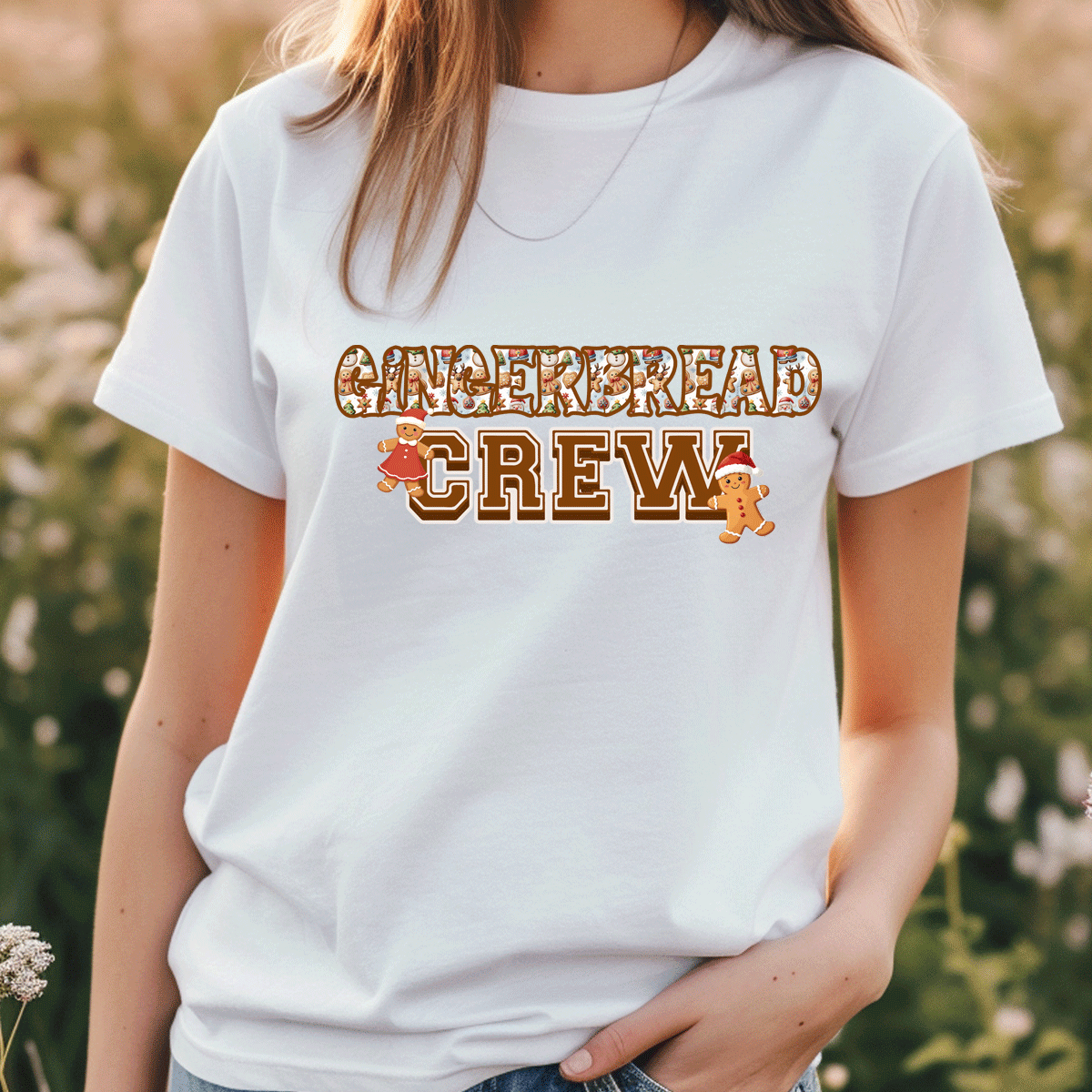 Person wearing a white t-shirt with 'GINGERBREAD CREW' text and graphics outdoors.