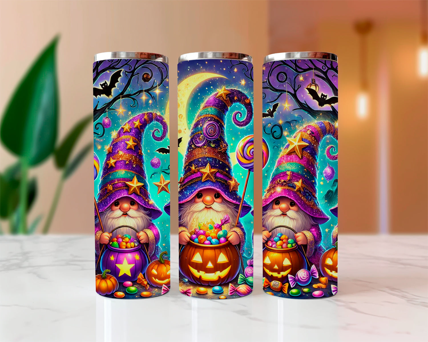 Three colorful tumblers with gnomes and Halloween elements on a white surface.