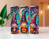 Three colorful tumblers with gnomes and Halloween elements on a white surface.