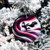 Decorative Christmas ornament with a colorful swirl design hanging on a snow-covered tree.