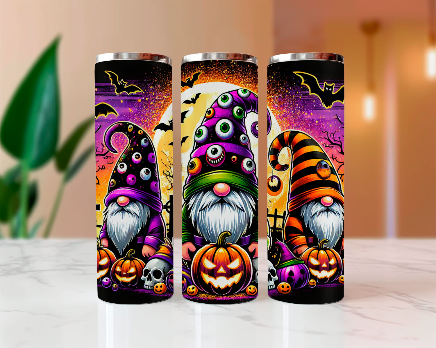 Three Halloween-themed tumblers with gnomes and pumpkins on a white surface.