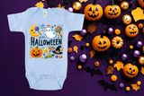 Light blue baby onesie with Halloween design on a purple background with pumpkins and decorations