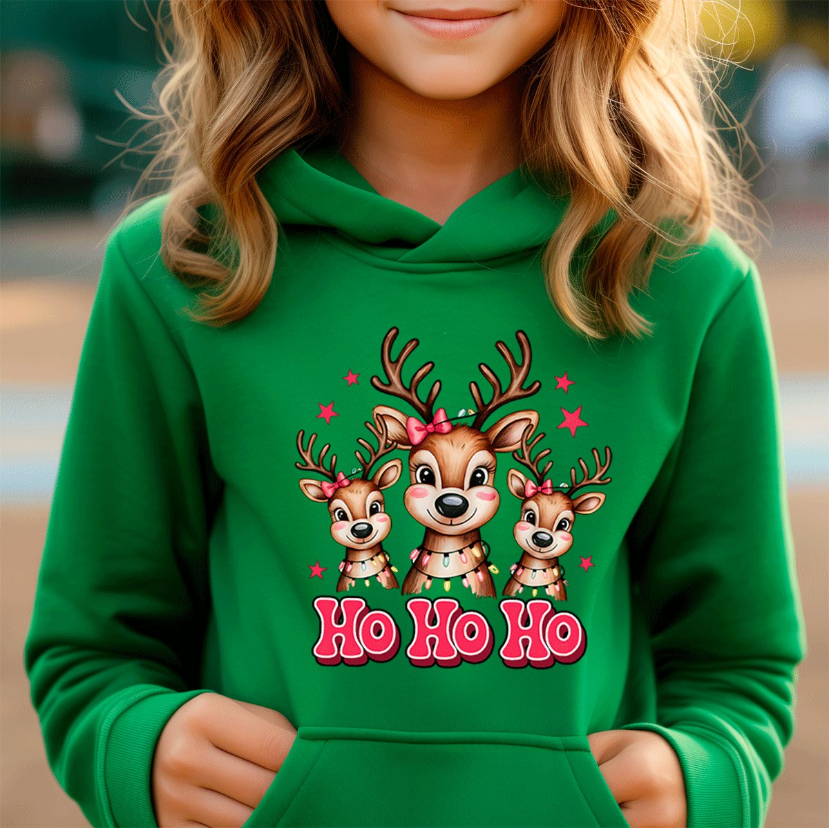 Child wearing a green hoodie with reindeer design and 'Ho Ho Ho' text.