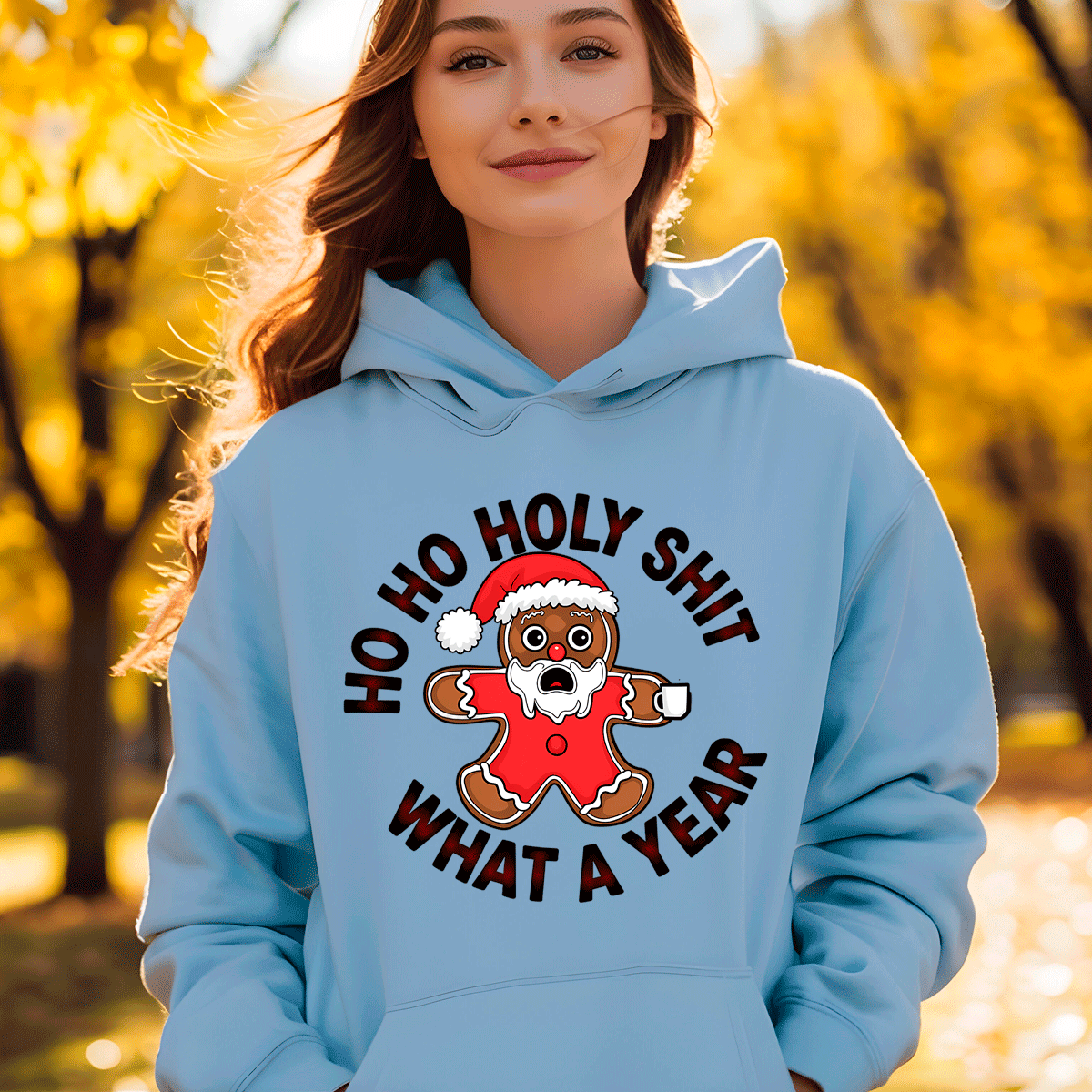 Person wearing a light blue hoodie with a gingerbread man graphic and text in an outdoor setting.