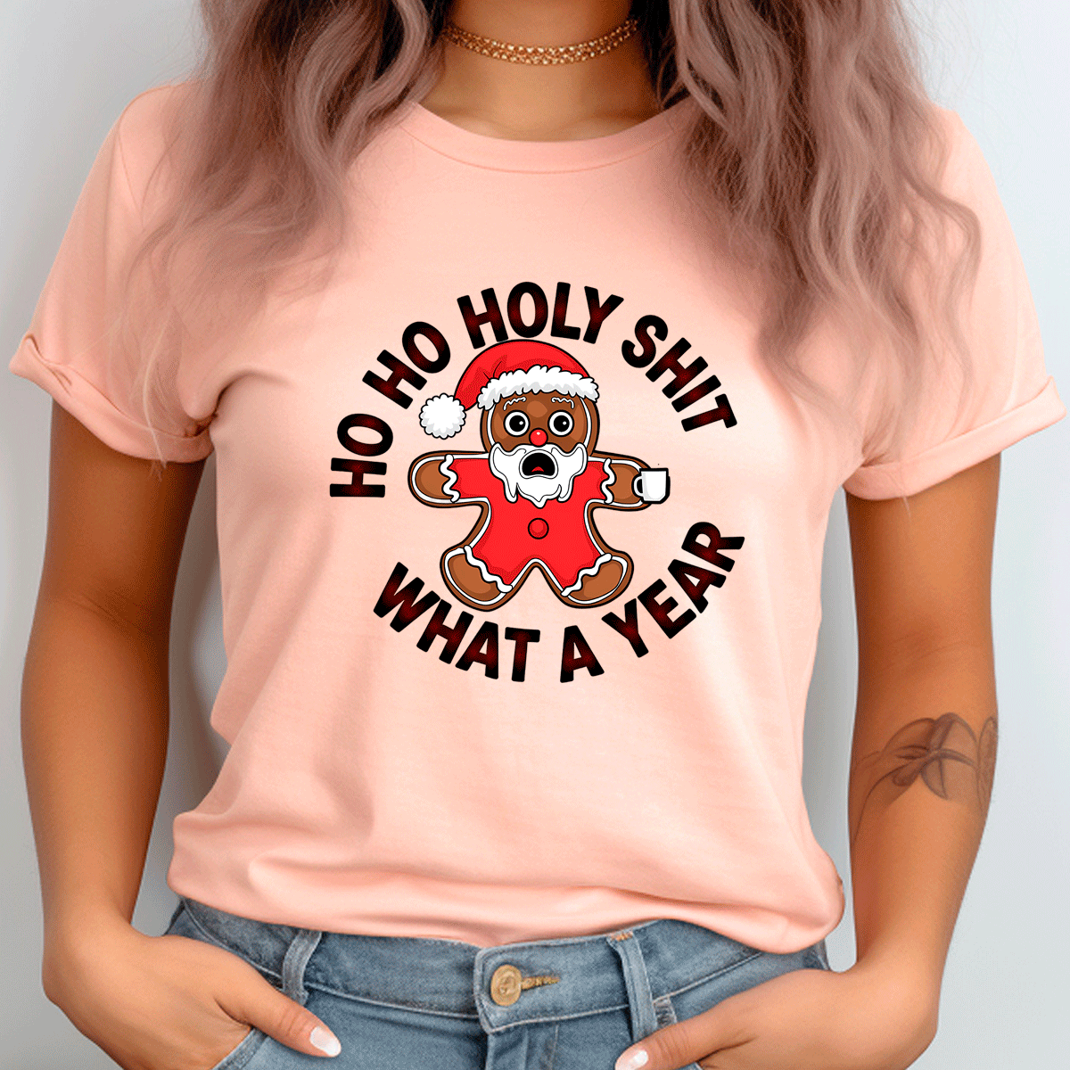 Person wearing a pink t-shirt with a Christmas-themed graphic and text.