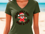 Person wearing a green t-shirt with a Christmas-themed graphic on a beach.