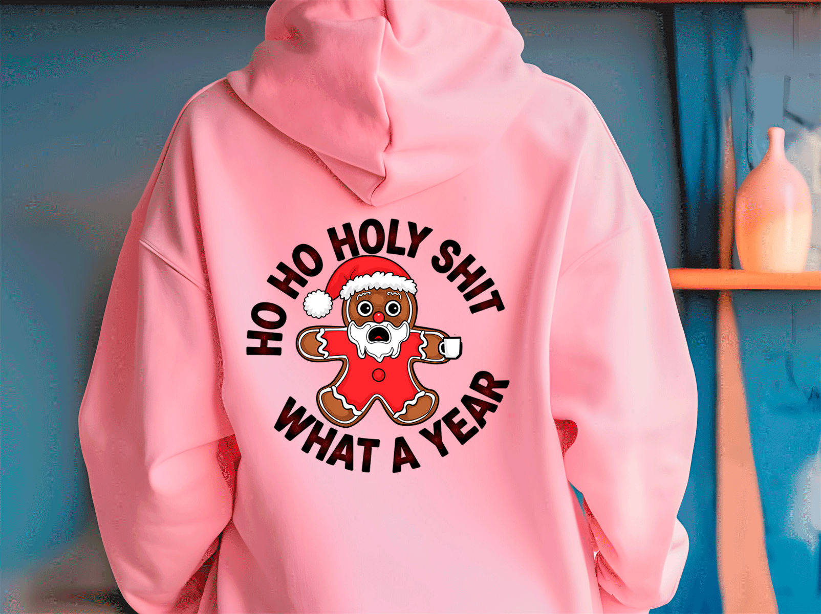 Pink hoodie with a graphic design and text on the back, against a blue wall.