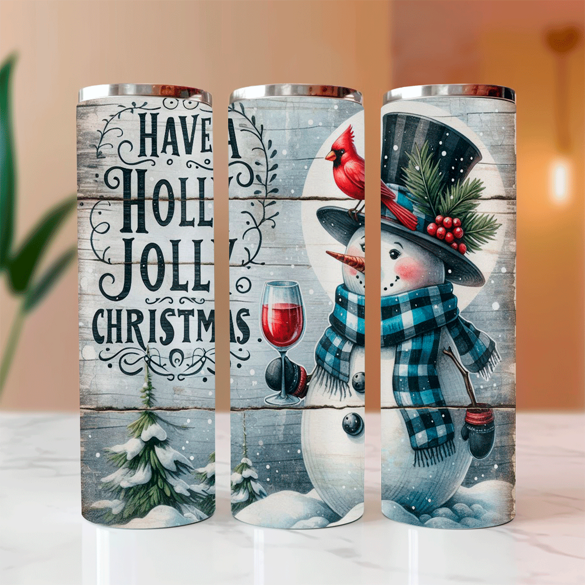 Three Christmas-themed tumblers with snowman and holiday designs on a wooden surface.