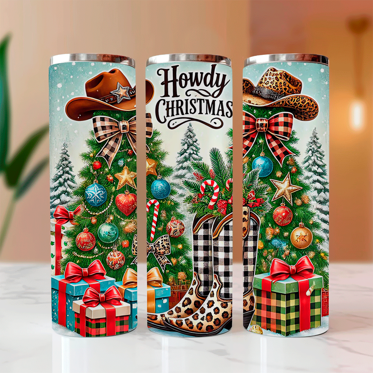 Three cylindrical Christmas-themed tumblers with decorative designs on a light surface.