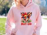 Person wearing a pink hoodie with a reindeer graphic and 'BUT I DO' text outdoors.