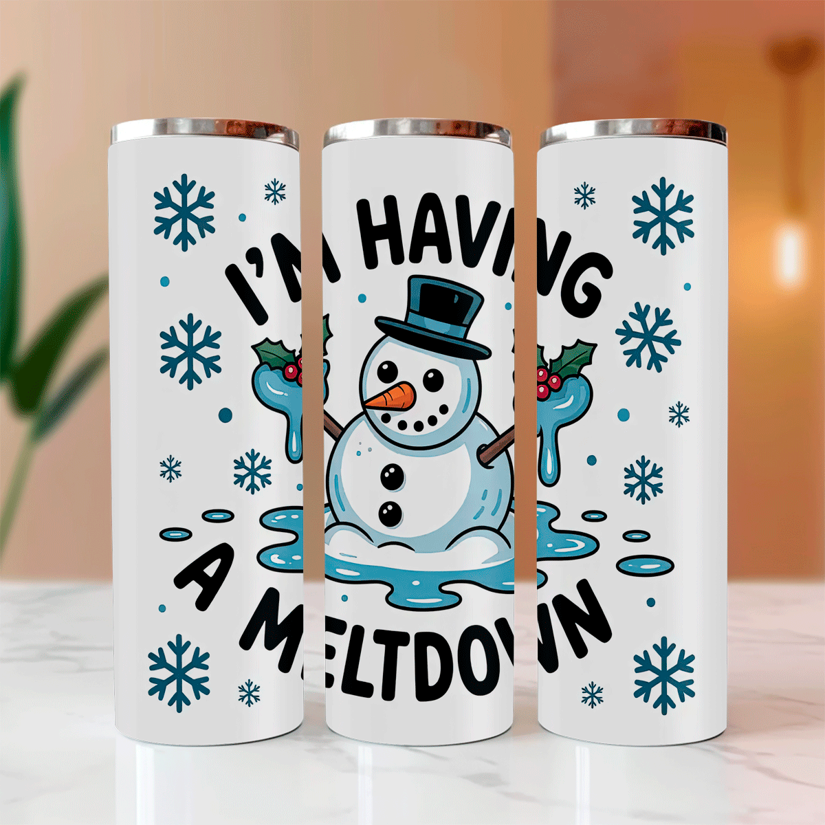 Three white tumblers with snowman design and text on a blurred background
