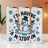 Three white tumblers with snowman design and text on a blurred background