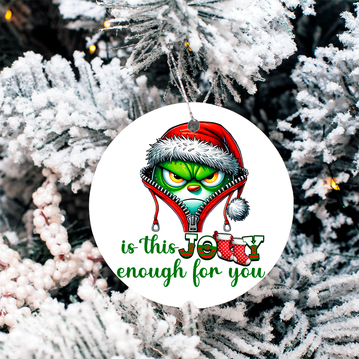 Christmas ornament with Grinch face and text 'is this Jolly enough for you' on a snowy tree background