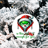 Christmas ornament with Grinch design on a snowy tree background