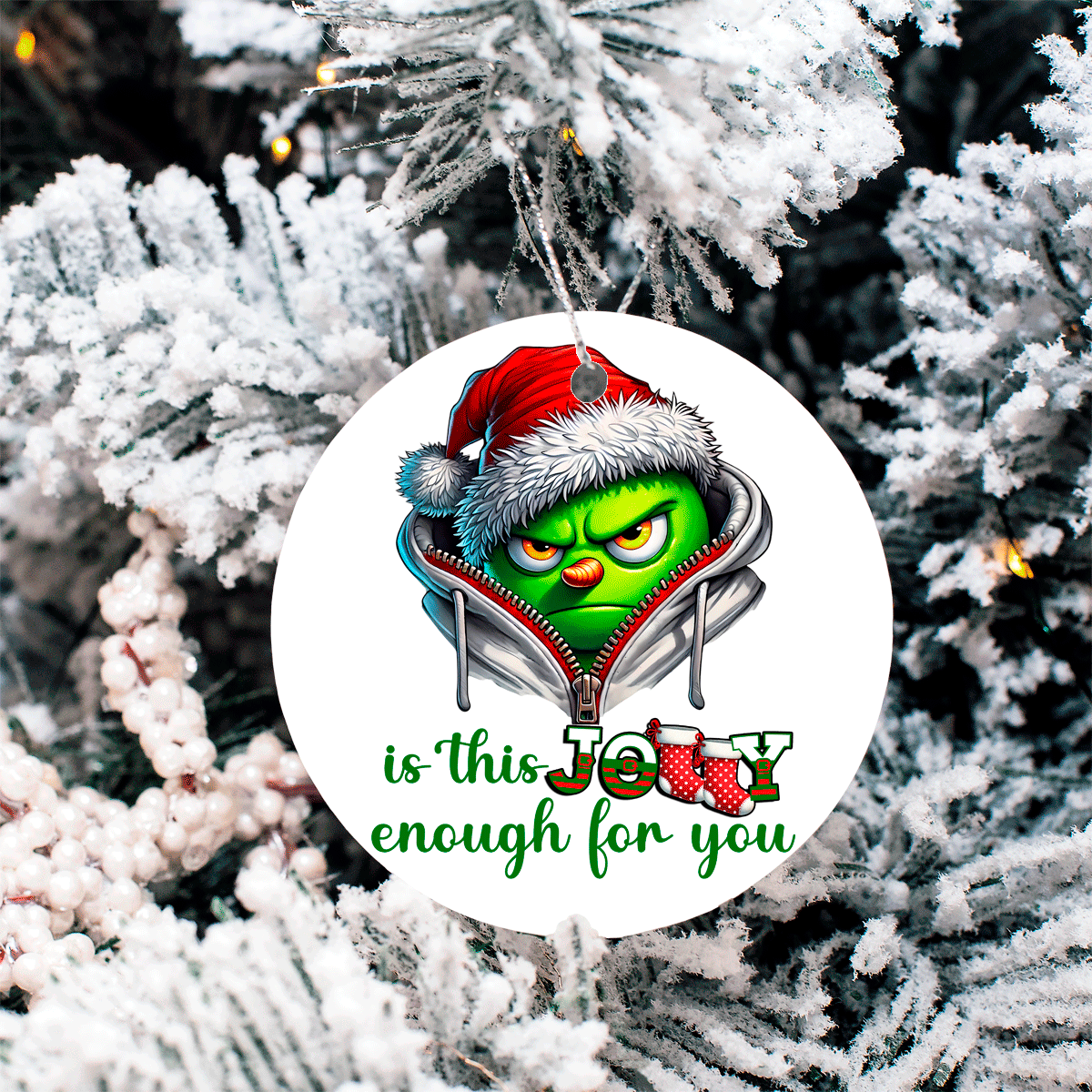 Christmas ornament with Grinch face and text 'is this Jolly enough for you' on a snowy tree background
