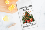 Tea towel with Christmas tree design and humorous text on a kitchen counter with lemons.
