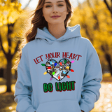 Person wearing a light blue hoodie with a heart design and text in an outdoor setting.