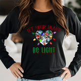 Person wearing a black long-sleeve shirt with a colorful heart design and text.