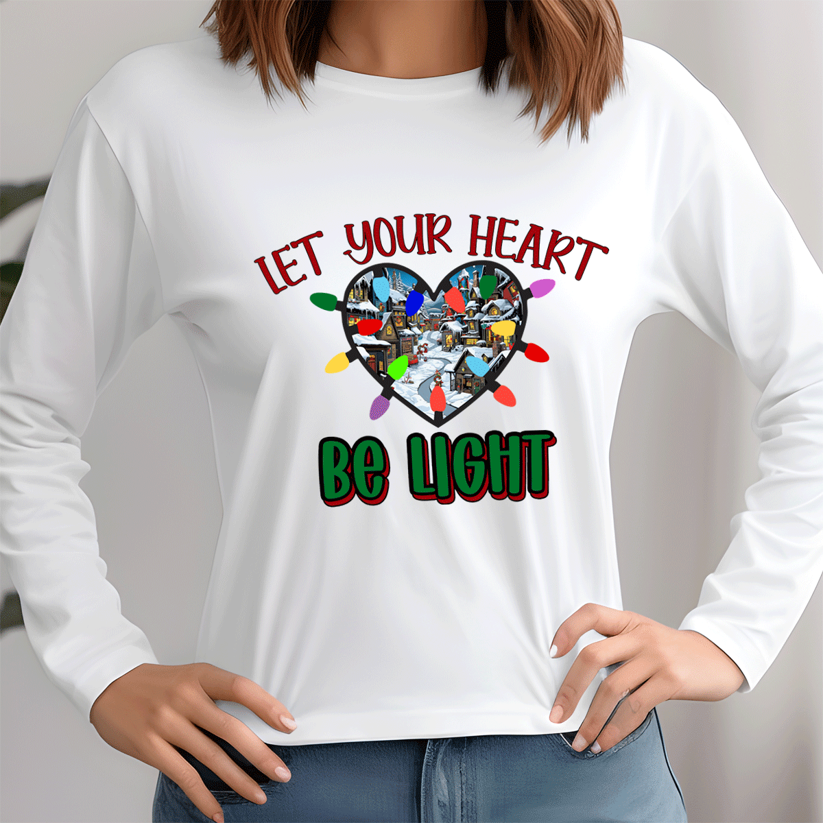 White long-sleeve shirt with a heart design and text 'Let Your Heart Be Light' on a plain background