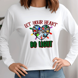 White long-sleeve shirt with a heart design and text 'Let Your Heart Be Light' on a plain background