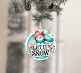 Christmas ornament with snowman design and 'Let It Snow' text, hanging on a tree.