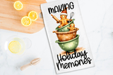Tea towel with gingerbread man design and text 'Making Holiday Memories' on a kitchen counter with lemons.
